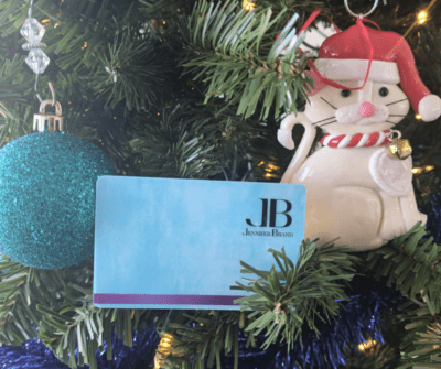 Jennifer Brand Massage gift cards in a Christmas tree next to a cute ornament.